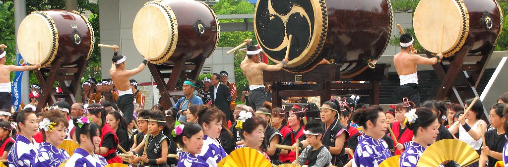 a hundred taiko drums in front of Kanazawa Station's drum gate at the Hyakumangoku Festival Parade