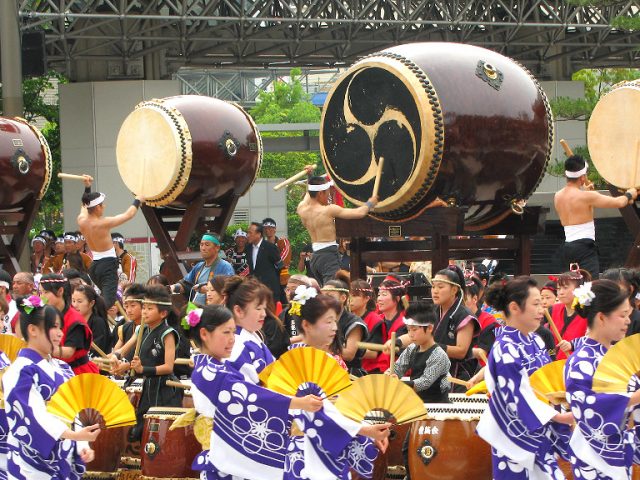 a hundred taiko drums in front of Kanazawa Station's drum gate at the Hyakumangoku Festival Parade