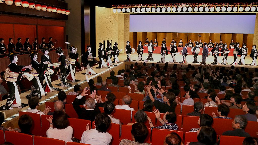 Kanazawa Odori event, photo from hokurikushinkansen-navi.jp, in which around 50 geisha dance together on a large stage