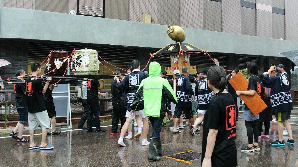 A gold persimmon on top of a mikoshi walking shrine at Kakinokibatake's Mizukake Festival in Kanazawa, Japan