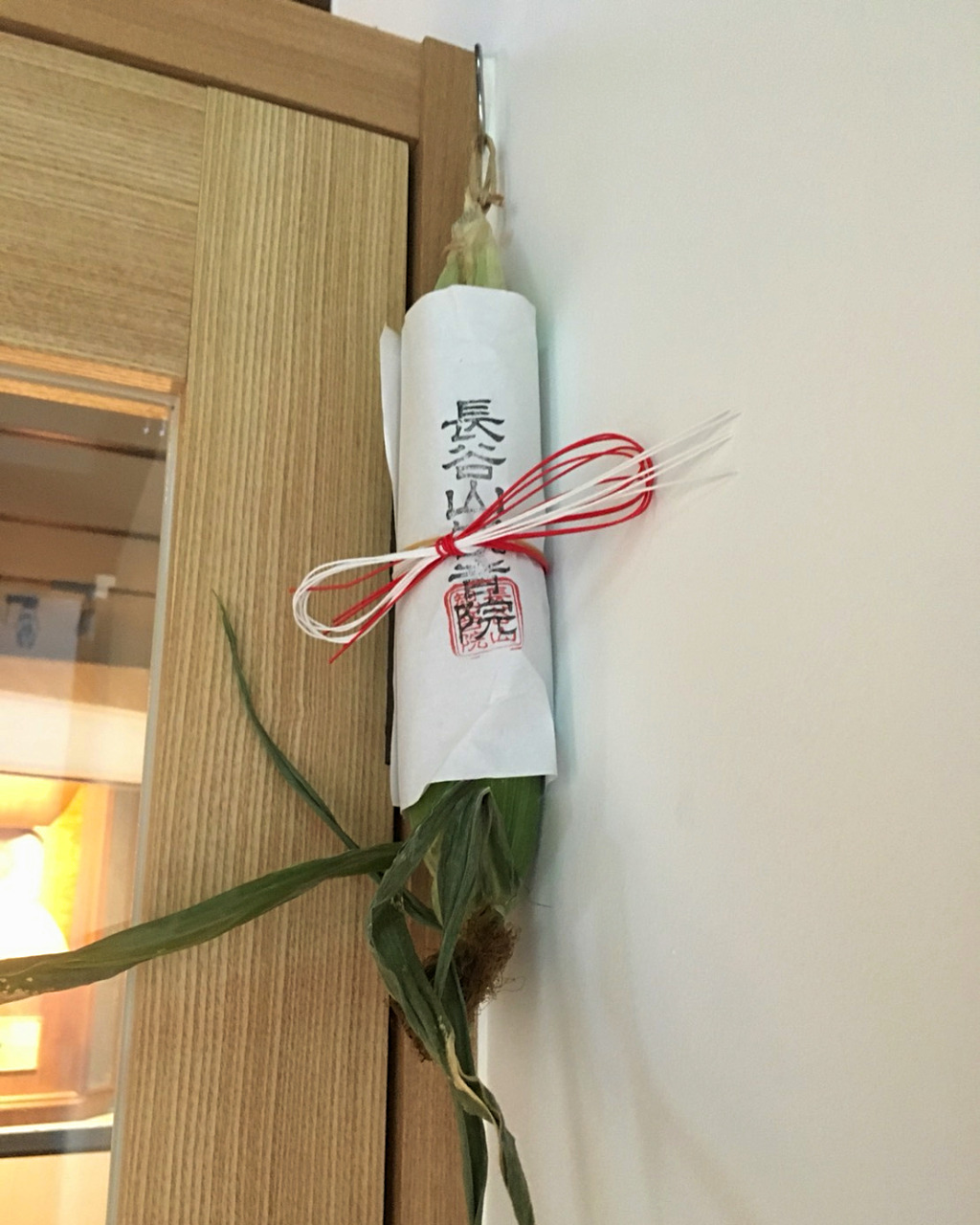 Shimanrokusen nichi good luck corn hanging in the doorway at Kaname Inn and Kanazawa Music Bar