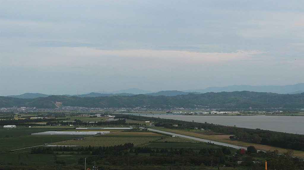 View of the Japanese Alps and the Kahoku Lagoon near farmland, in Uchinada, Japan