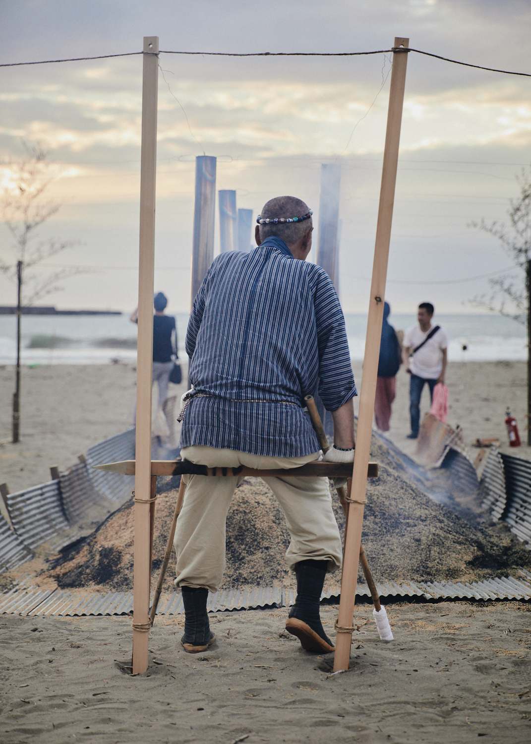 Master Iida overseas the slow burn of the wild kiln of noyaki, earthenware baking on Kanaiwa Beach in Kanazawa, Japan.