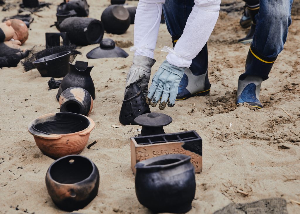 Baked earthenware from the Noyaki wildfire kiln takes on variegated colors of adobe, black, and silver.