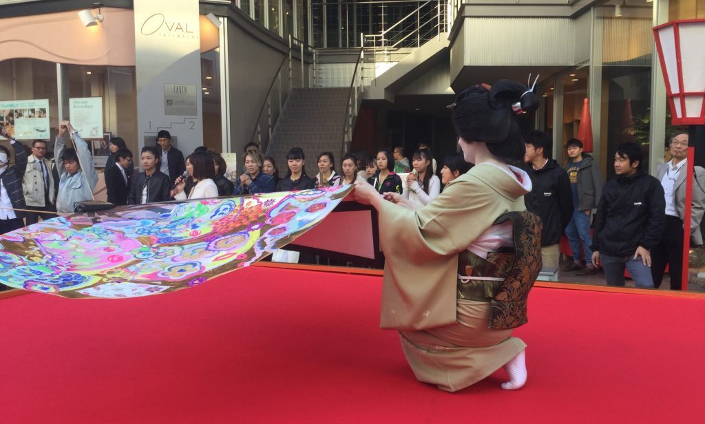 Geisha of Nishi Chaya try their hands at flying the monster folding fan