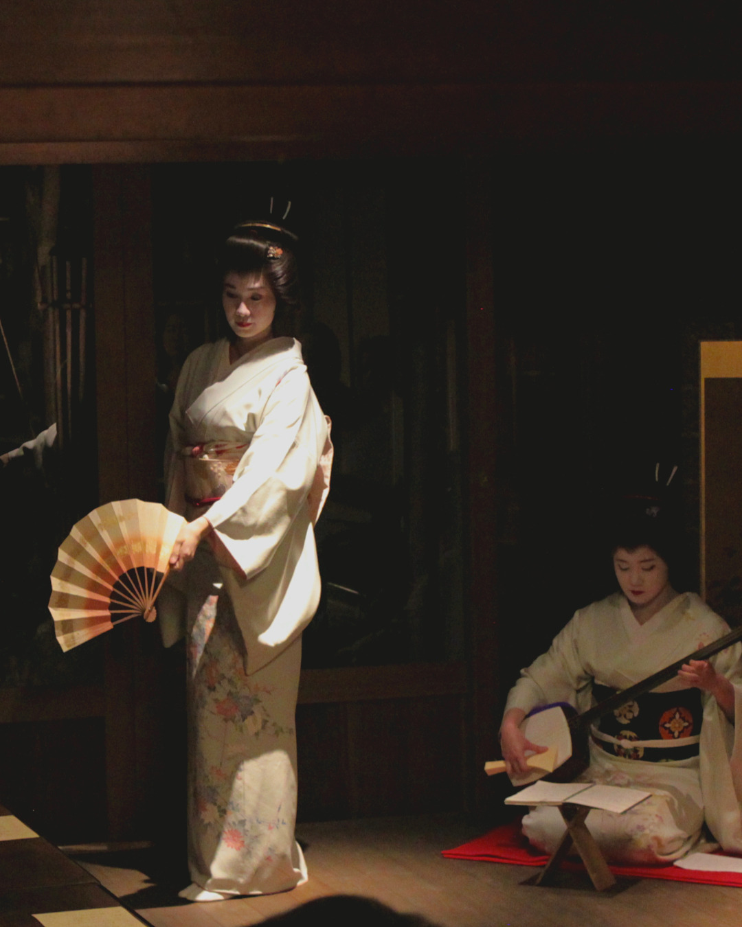 Geisha performing under a spotlight, at the In Kanazawa House performance event