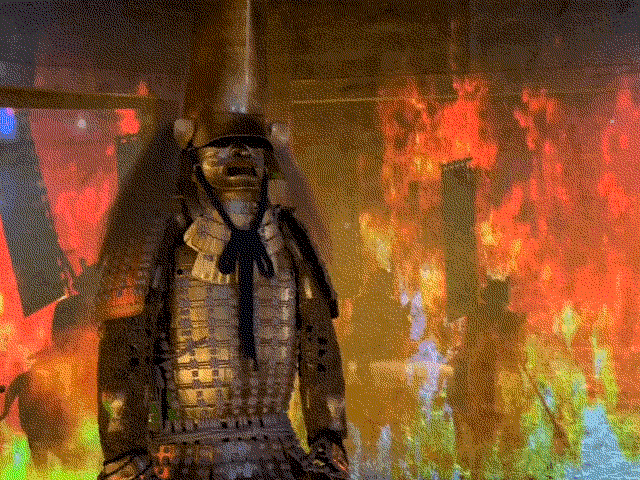 The Gold Samurai Armor at Hakuichi against a fiery background, image by Rachel at Kaname Japan