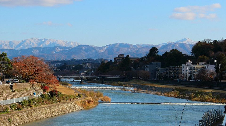 The Saigawa River in Kanazawa in autumn, with mountain view.