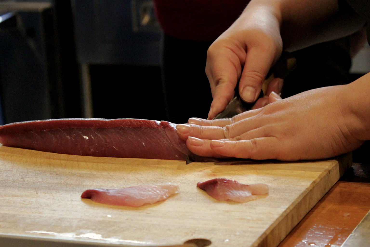 Naoko denonstrates the correct angle for cutting sashimi during her cooking class in Kanazawa, Japan