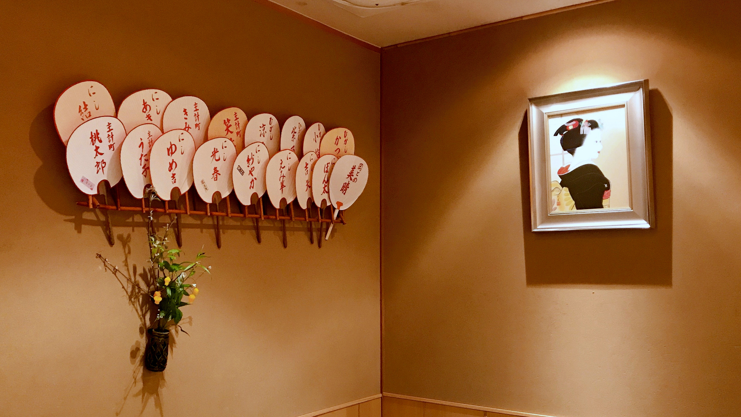 Summertime fans, flowers and a Japanese painting of a geisha decorate the walls of Kanazawa's fine dining restaurant, Yokoyama