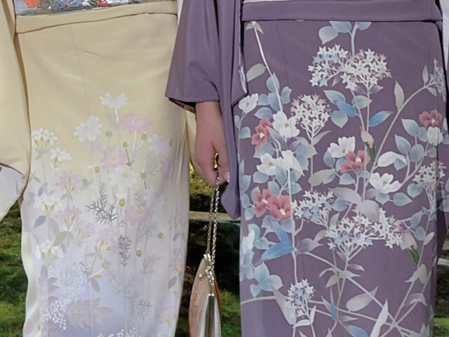 Close of up the skirt section of two Kaga-yuzen kimono, detailed with flowers, one purple and one yellow