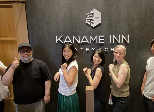 Kaname Inn Tatemachi staff pose at the front desk after receiving their second shots of SARS-CoV-2 vaccination
