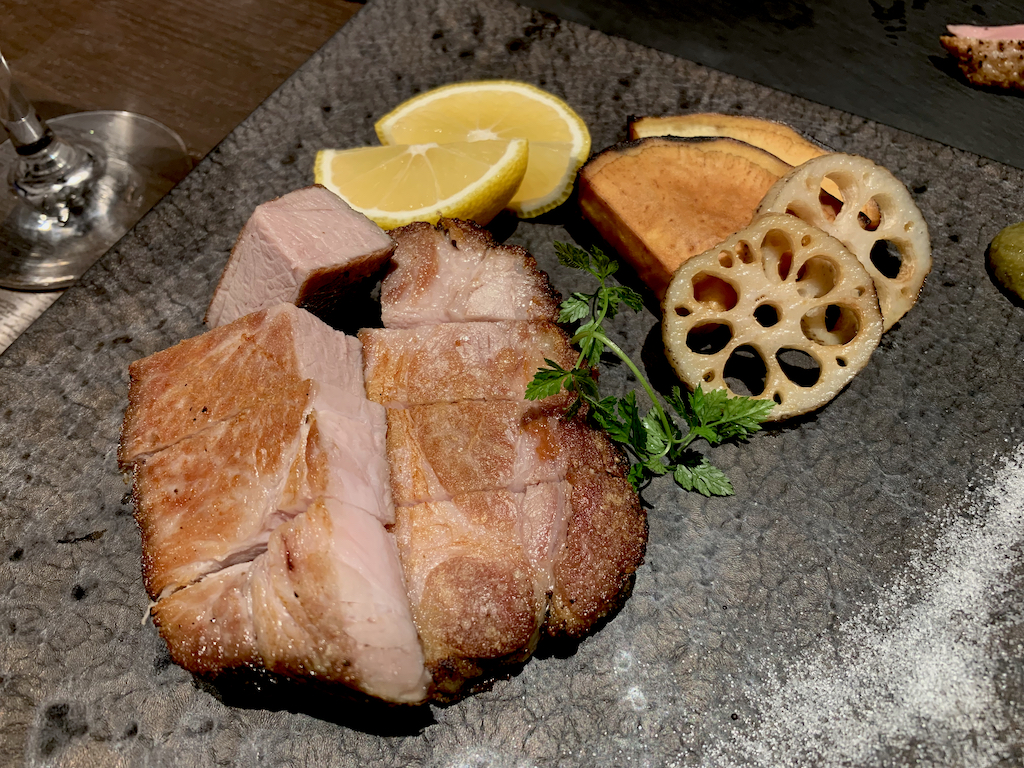 grilled noto pork served with vegetables on a plate with salt and wasabi at Oriental Brewery in Kanazawa