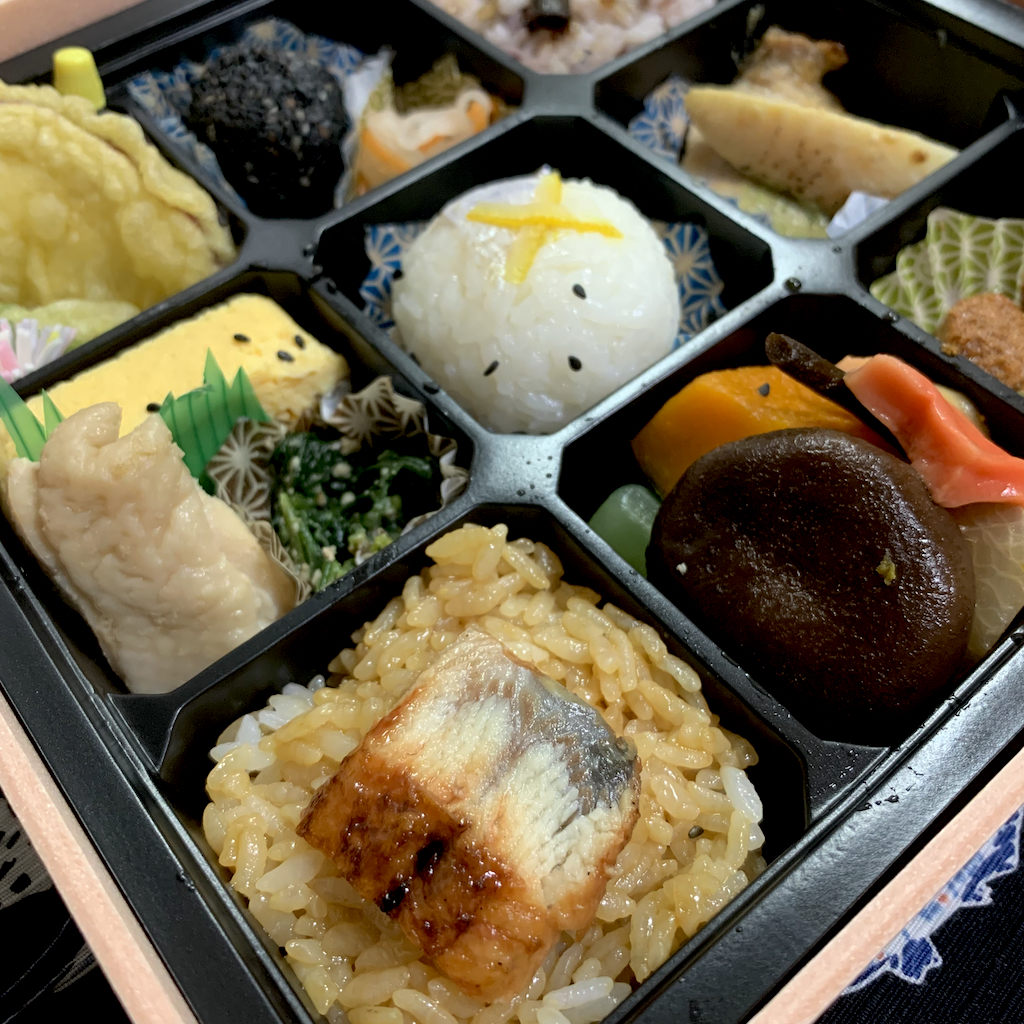 A bento box of nine squares of various Japanese dishes