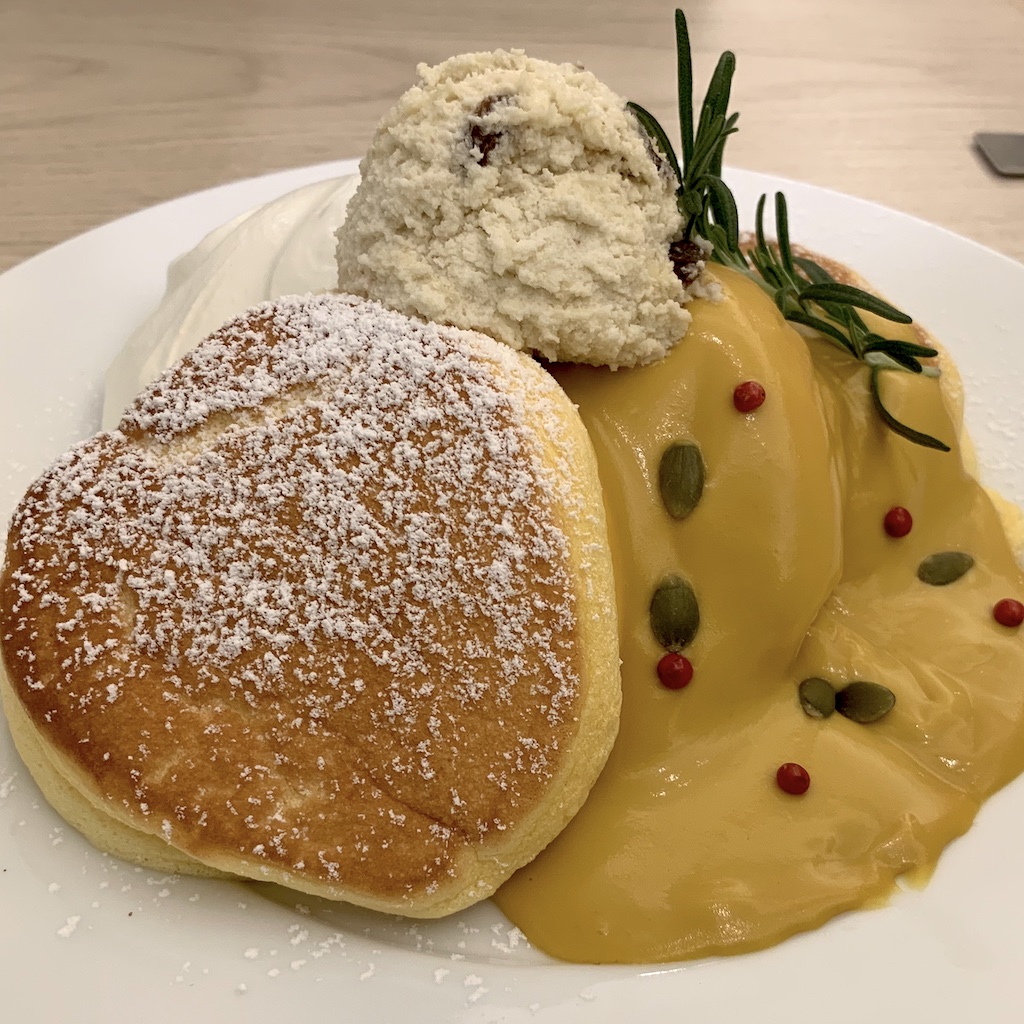 Fluffy, Japanese pancakes buried under a sweet pumpkin sauce, raisin butter, and rosemary