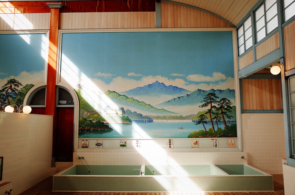 interior mural of mountainside in a wood and tile sento, photography by Soyoung Han of Unspalsh